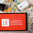 A tablet with the logo of the London School of Economics surrounded by a computer mouse and paper clips