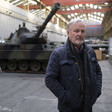 A man stands in front of a tank 