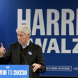 Former President Bill Clinton speaks in Milwaukee, Wisconsin in front of a Harris-Walz sign and an American flag