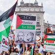 A protester holds a sign with a Palestine flag and mug shot of Netanyahu readingg "ICC justice for Bibi"