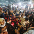 Crowd of men and boys put their arms up in the air