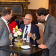 Israel's Amos Yadlin holds a glass of wine as he chats to two other men 