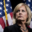 Congresswoman Claudia Tenney with two American flags behind her