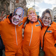 Three people wear orange jump suits and masks of Israel's Benjamin Netanyahu, America's Donald Trump and the European Union's Ursula von der Leyen