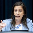 Congresswoman Elise Stefanik at microphone emphasizes a point with her hand