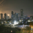 City skyline with bright smoke trails from missiles