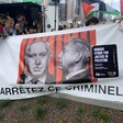 A banner featuring a photograph of the Israeli Prime Minister with a moustache similar to that of Adolf Hitler and a slogan reading Arrêtez Ce Criminel, French for Arrest This Criminal.