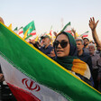 Woman surrounded by people holds Iranian flag