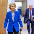 European Commission President Ursula von der Leyen wearing a blue suit and carrying a folder 