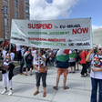 Three women hold a sign saying Suspend the EU-Israel Association Agreement
