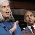 Congresswoman Katherine Clark speaks from a podium as Congressman Hakeem Jeffries looks on