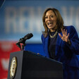 Kamala Harris gesticulates from behind a podium