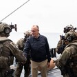 German Chancellor Friedrich Merz shakes hand with a uniformed soldier as other uniformed soldiers stand beside him