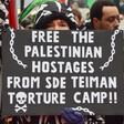 Woman at demonstration holds sign reading "Free the Palestinian hostages from Sde Teiman torture camp"