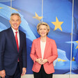 Former British Prime Minister Tony Blair stands beside European Commission President Ursula von der Leyen in front of a blue backdrop featuring yellow stairs