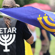 Man wears Betar t-shirt and holds Betar flag