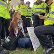 A woman holding a sign surrounded by police