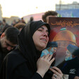 A woman embraces a portrait of Ali Khamenei