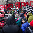Protesters carry signs criticizing the Gaza genocide and AIPAC