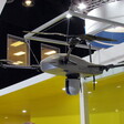 A quadcopter drone on display against a yellow background with the logo of Elbit Systems partly visible 