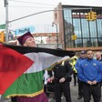 A graduating student with a Palestinian flag protests in New York City as police look on