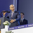 Man in suit speaks from a podium