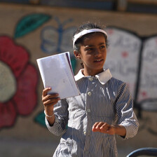 Girl in school uniform holds book