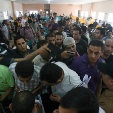 Men holding passports crowd at crossing terminal