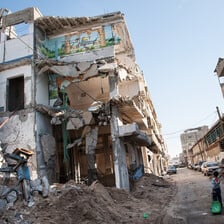 Boy walks past destroyed building exposing mural of Dome of the Rock in Jerusalem