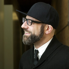 Portrait photograph of bearded man wearing cap