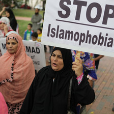 Woman carries sign reading Stop Islamophobia