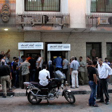 Men queue in front of bank building
