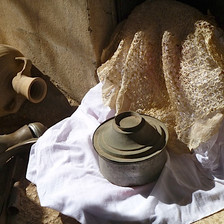 Vessels and pots sit on fabric