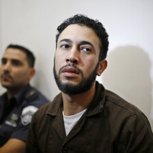 Close-up of young man wearing brown prison uniform