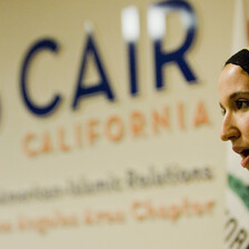 Woman stands in front of Council on American-Islamic Relations sign