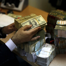 Close-up of hands handling stacks of various paper curreincies