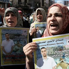 Women march and hold posters of political prisoners