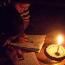 Boys read by candle light