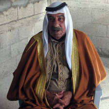 Candid portrait of older man wearing long robes and traditional headdress