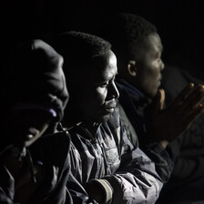 Close-up of men wearing winter coats sitting at night