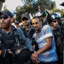 Israeli forces in riot gear arrest young man with blood smeared on his mouth