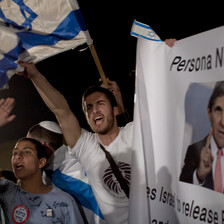 Young people wave Israeli flags during nighttime rally