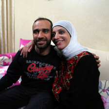 Smiling woman wearing traditional dress hugs young man