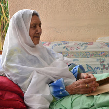 Elderly woman sits in bed
