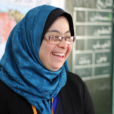 Close-up of smiling woman standing at front of classroom