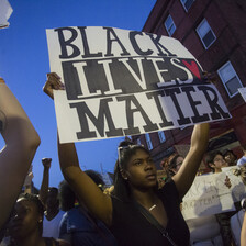 Woman holds sign reading Black Lives Matter during demonstration