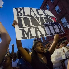Woman holds sign reading Black Lives Matter during demonstration