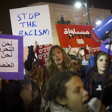 Protesters carry signs against racism