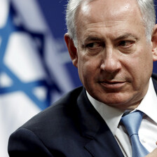 Close-up of Netanyahu with Israeli flag behind him