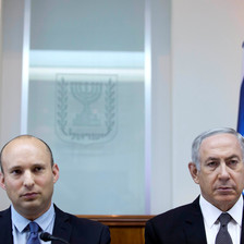 Naftali Bennett and Benjamin Netanyahu stand shoulder-to-shoulder in front of Israeli flag